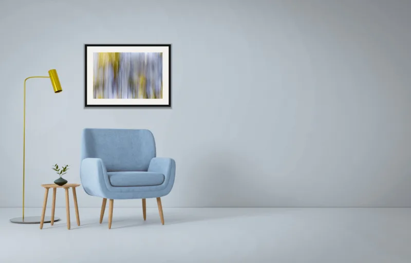 Forest dream I shown framed as an A2 print, above a pale blue armchair on a grey wall
