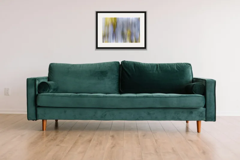 Forest dream I shown framed as an A3 print, above a green velvet sofa against a white wall