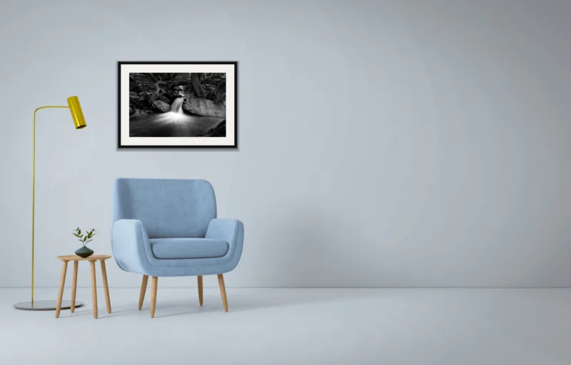 Forest falls shown framed as an A2 print, above a pale blue armchair on a grey wall