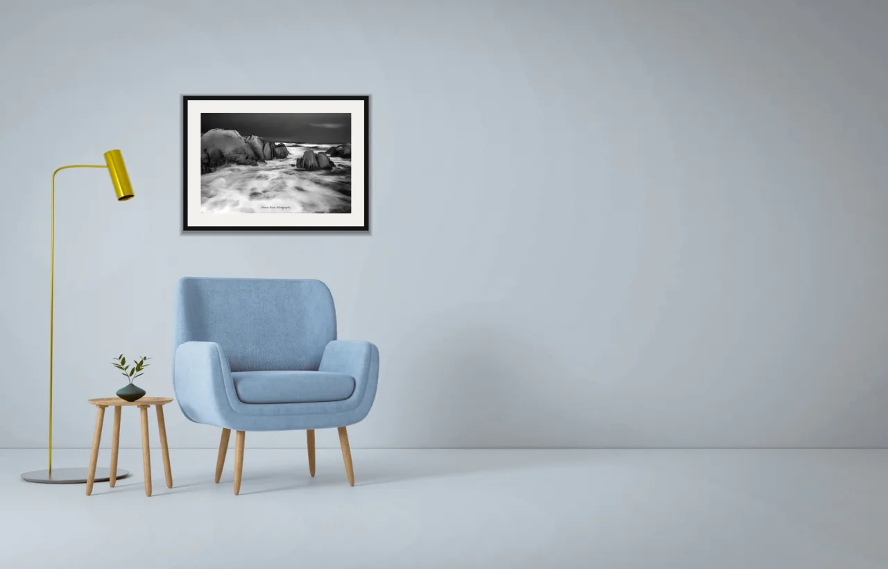 Granite and surf as a framed A2 print, above a pale blue armchair on a grey wall