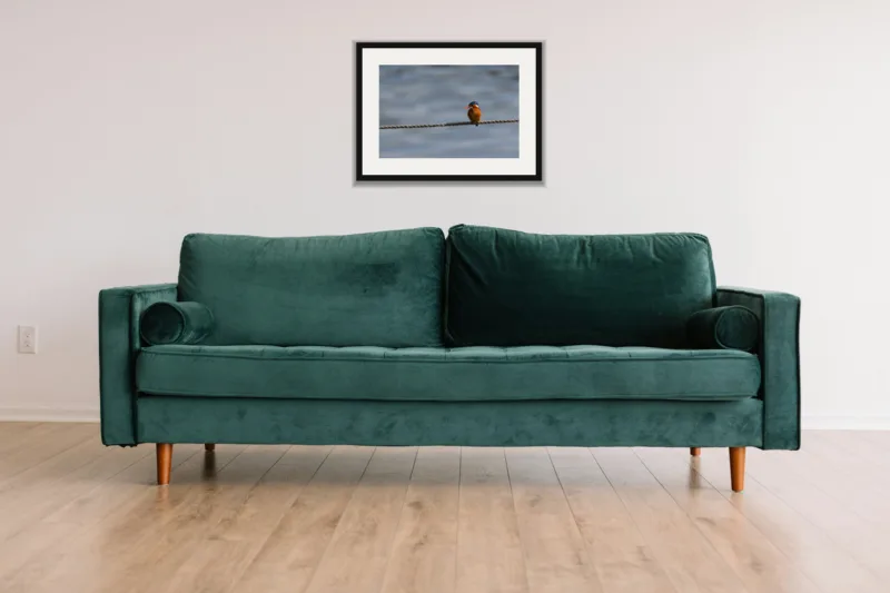 Tightrope shown framed as an A3 print, above a green velvet sofa against a white wall