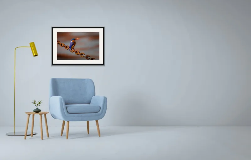 Rust and sapphire shown framed as an A2 print, above a pale blue armchair on a grey wall