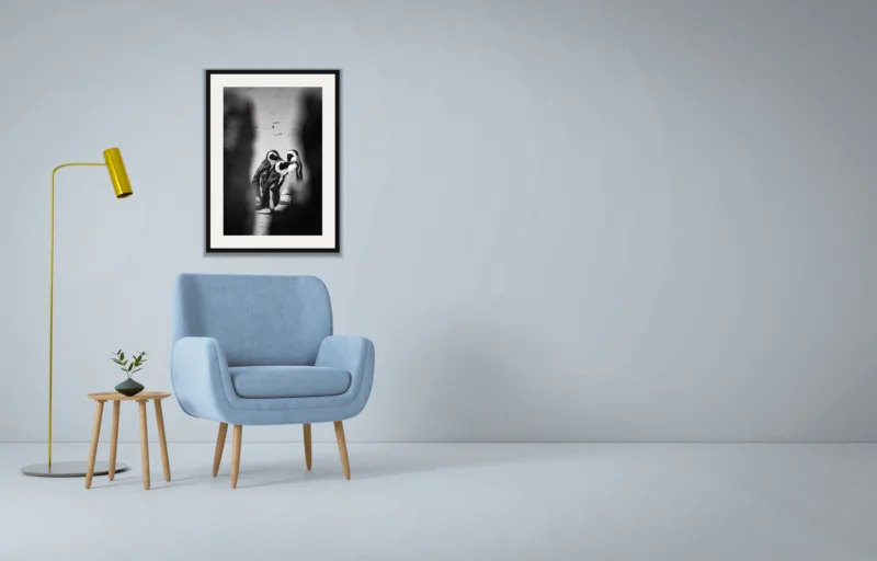 Three’s company shown framed as an A2 print, above a pale blue armchair on a grey wall